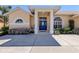 Attractive home featuring a well-manicured front yard, a bright blue front door, and a charming architectural design at 4358 Via Del Villetti Dr, Venice, FL 34293