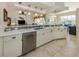 Kitchen with stainless steel dishwasher, modern sink and long countertop with view to dining and living areas at 4358 Via Del Villetti Dr, Venice, FL 34293