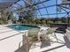 Inviting screened-in pool area with a hot tub, grill, lounge chairs, and manicured landscaping at 4358 Via Del Villetti Dr, Venice, FL 34293