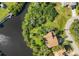 Aerial view of a brown roof house situated next to a lake and lush foliage at 440 Monza Ave, North Port, FL 34287