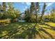 Backyard of a two-story home surrounded by trees and greenery creating a private outdoor space at 440 Monza Ave, North Port, FL 34287