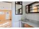 A quaint bathroom features tiled walls, mirror and open doorway to the main area at 440 Monza Ave, North Port, FL 34287