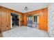 View of an empty room with wood panel walls and view to the kitchen and lanai at 440 Monza Ave, North Port, FL 34287