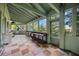 Bright sunroom with large windows, tile floors, and a rustic workbench at 440 Monza Ave, North Port, FL 34287