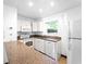 Well-lit kitchen featuring white cabinetry, granite countertops, and modern white appliances at 510 Airport E Ave # 2D, Venice, FL 34285