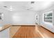 Open-concept living space with hardwood floors, large window, and partial kitchen view at 510 Airport E Ave # 2D, Venice, FL 34285