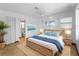 Serene main bedroom with coastal decor, a woven bed frame, and an en-suite bathroom at 510 Airport E Ave # 2D, Venice, FL 34285