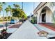 A sidewalk in Venice with palm trees, cars, and storefronts in the background at 510 Airport E Ave # 2D, Venice, FL 34285