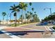 A palm tree lined street in Venice with a blue car on a sunny day at 510 Airport E Ave # 2D, Venice, FL 34285