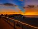 Scenic view of the pier at sunset with people walking along the beach at 510 Airport E Ave # 2D, Venice, FL 34285