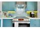 Close up of modern stainless steel stovetop and exhaust hood in the kitchen with custom backsplash at 5138 Harpers Croft # 12, Sarasota, FL 34235