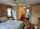 Bedroom with wood paneling and attached bathroom with vanity and stool at 530 Via Veneto, Venice, FL 34285