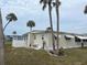 This one-story home features window awnings, a back patio, and a few beautful palm trees at 530 Via Veneto, Venice, FL 34285