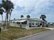 This cozy one-story home features window awnings, landscaping, and is beautifully landscaped with palm trees at 530 Via Veneto, Venice, FL 34285