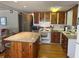This home features a kitchen with hardwood flooring, white appliances, and a granite island at 530 Via Veneto, Venice, FL 34285
