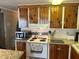 This home features a charming kitchen with hardwood flooring, white appliances, and wooden cabinets at 530 Via Veneto, Venice, FL 34285