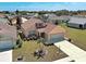 Aerial view of a home with manicured lawn, complemented by a driveway leading to a garage at 589 Rose Apple Circle, Port Charlotte, FL 33954