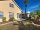 Backyard view featuring sliding glass door and lush landscaping with decorative concrete border at 589 Rose Apple Circle, Port Charlotte, FL 33954