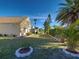 Expansive backyard featuring lush landscaping, trimmed green grass, and mature palm trees at 589 Rose Apple Circle, Port Charlotte, FL 33954