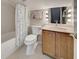 Cozy bathroom featuring a shower and tub combination and a wooden vanity with stylish lighting at 589 Rose Apple Circle, Port Charlotte, FL 33954