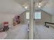 View of carpeted bedroom with window and ceiling fan, adjoining what appears to be a workout room at 589 Rose Apple Circle, Port Charlotte, FL 33954