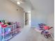 Bright bedroom featuring carpet flooring, shelves filled with toys and decor, and a ceiling fan at 589 Rose Apple Circle, Port Charlotte, FL 33954