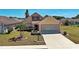 Charming home with manicured lawn, complemented by a paved driveway leading to a two-car garage at 589 Rose Apple Circle, Port Charlotte, FL 33954