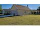 Exterior showcasing a two-car garage with trimmed grass and some low bushes at 589 Rose Apple Circle, Port Charlotte, FL 33954