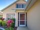 Home's front door with some nice, trimmed bushes and a hanging flower basket at 589 Rose Apple Circle, Port Charlotte, FL 33954