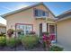 Home's entry featuring hanging flowers and a trimmed green lawn surrounded by some healthy bushes at 589 Rose Apple Circle, Port Charlotte, FL 33954