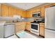 Well-lit kitchen with stainless steel appliances and natural wood cabinetry at 589 Rose Apple Circle, Port Charlotte, FL 33954