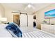 Sunlit main bedroom with sliding barn door to en suite bathroom and beach-themed decorations at 589 Rose Apple Circle, Port Charlotte, FL 33954