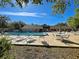 Community pool with a view of a clubhouse, surrounded by seating and well-kept landscaping at 589 Rose Apple Circle, Port Charlotte, FL 33954