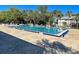 Resort-style swimming pool with lounge chairs, tables, umbrellas, and lush landscaping for relaxation and enjoyment at 589 Rose Apple Circle, Port Charlotte, FL 33954