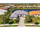 A stunning aerial view of the property shows the front yard, beautiful landscaping, and brick driveway at 611 Sawgrass Bridge Rd, Venice, FL 34292