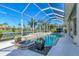 Beautiful screened-in pool area with lush landscaping and water features, creating a resort-like backyard oasis at 611 Sawgrass Bridge Rd, Venice, FL 34292