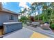 Lush backyard featuring a hot tub, cozy seating, and mature trees, creating a private oasis at 740 Tanager Rd, Venice, FL 34293