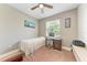 Well-lit bedroom featuring a desk, wood floors, and a ceiling fan at 740 Tanager Rd, Venice, FL 34293