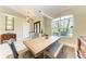 Dining room with a dining table with 4 chairs and a bench under a linear light fixture by a large window at 740 Tanager Rd, Venice, FL 34293