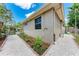 Side view of home with a gravel walkway, landscaped garden, and a glimpse of outdoor seating area at 740 Tanager Rd, Venice, FL 34293