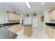 Bright kitchen featuring granite countertops, tan cabinetry, an island, and tile floors at 740 Tanager Rd, Venice, FL 34293