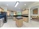 Open-concept kitchen with black appliances, tan cabinetry, an island, and tile floors at 740 Tanager Rd, Venice, FL 34293