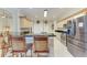 Bright kitchen featuring stainless steel appliances, tan cabinetry, and a breakfast bar with seating at 740 Tanager Rd, Venice, FL 34293