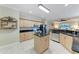 Well-equipped kitchen with stainless steel appliances, tan cabinetry, granite countertops, and an island at 740 Tanager Rd, Venice, FL 34293