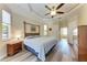 Comfortable bedroom with a bamboo headboard, ceiling fan, and plank flooring at 740 Tanager Rd, Venice, FL 34293