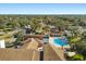 Overhead view of the pool and tennis courts available to community members, surrounded by mature trees and lush landscaping at 7515 Greystone Dr, Hudson, FL 34667