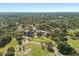 Expansive aerial view of a community featuring a golf course and clubhouse with lush trees and blue skies at 7515 Greystone Dr, Hudson, FL 34667