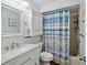 Bright bathroom featuring a vanity, toilet, and a shower with a stylish blue and white seashell-themed curtain at 7515 Greystone Dr, Hudson, FL 34667