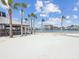 Inviting beach with soft white sand, palm trees, and a covered picnic area overlooking the water at 7515 Greystone Dr, Hudson, FL 34667