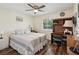 A well-lit bedroom with a bed, desk, ceiling fan, and wood flooring, offering a comfortable living space at 7515 Greystone Dr, Hudson, FL 34667